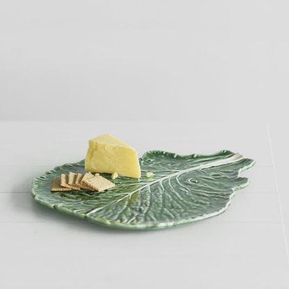 The Bordallo Pinheiro Cabbage Platter with cheese and crackers on it