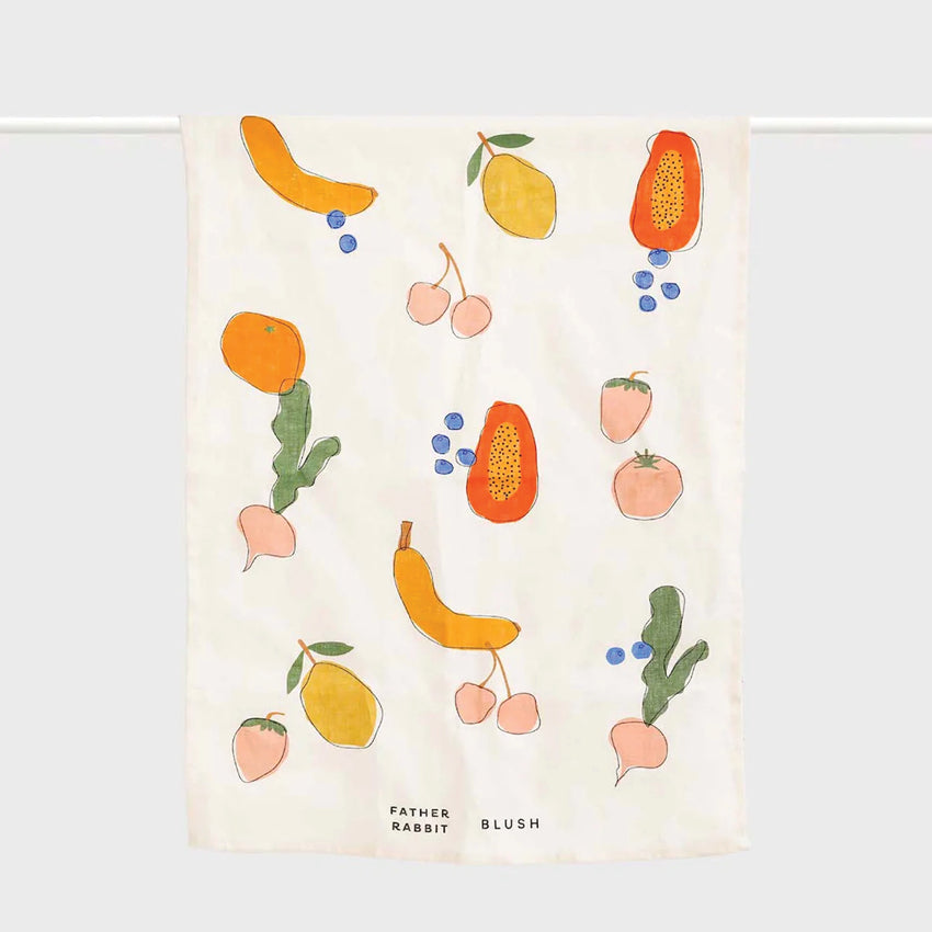 The Father Rabbit Tea Towel in Blush hanging on a rod on a blank background