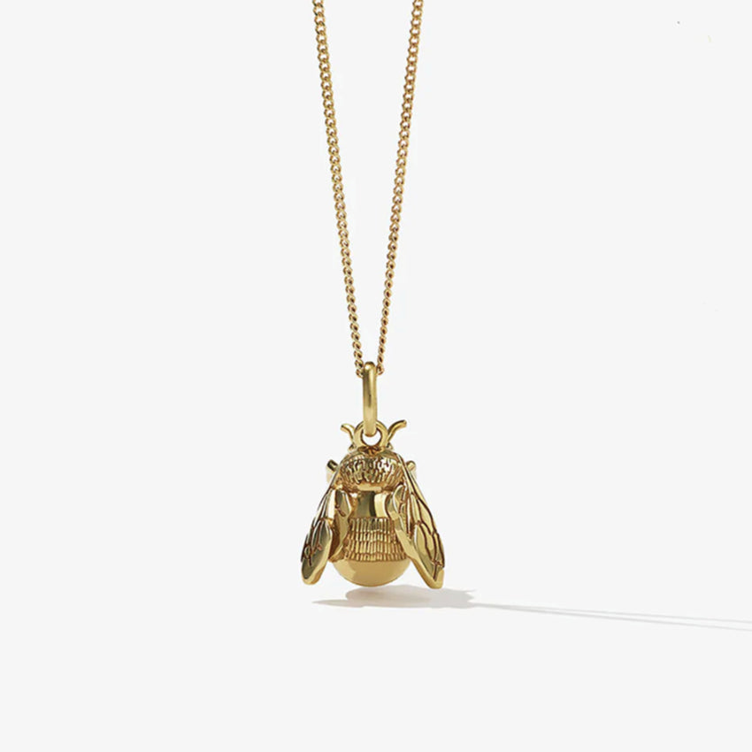The Meadowlark Bee Charm Necklace in Gold Plated on a blank background