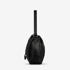 A side view of the Status Anxiety Point Of No Return Bag in Black on a blank background