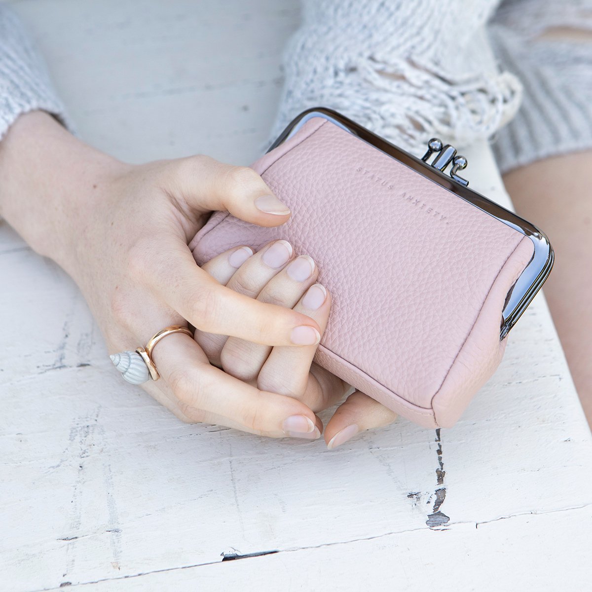 Status Anxiety Volatile Wallet in Dusty Pink in the hands of a person
