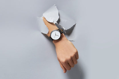 Status Anxiety Inertia Watch in Matte Black with White Face and Black Strap on Hand
